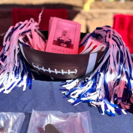 a table with a football bowl and pom-poms with some flyers